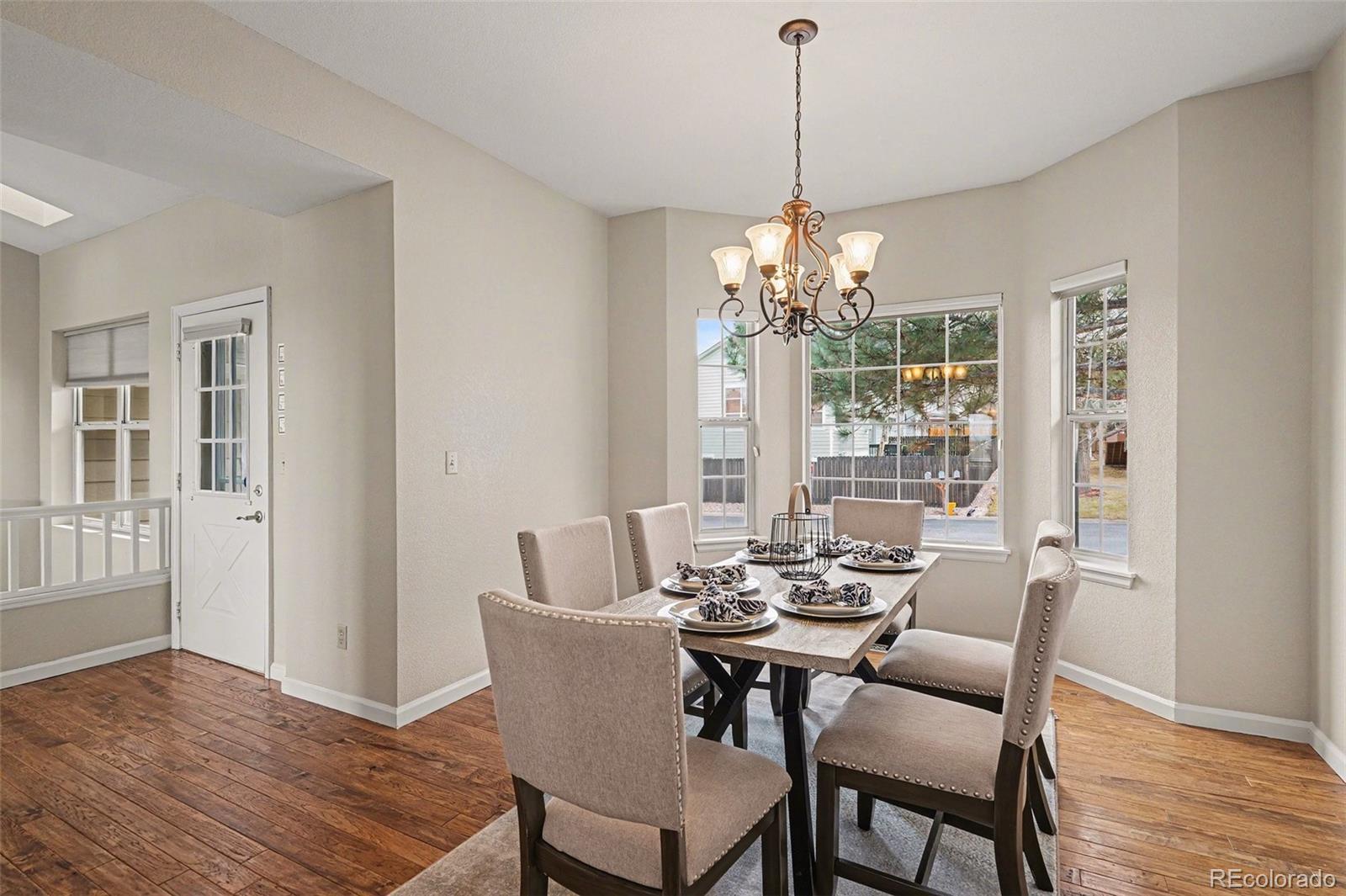 12271 West Chenango Drive Morrison, CO 80465 - Photo 9 of 37 a dining room with furniture a chandelier and wooden floor