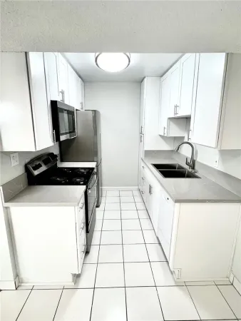 a kitchen with a sink and a stove top oven