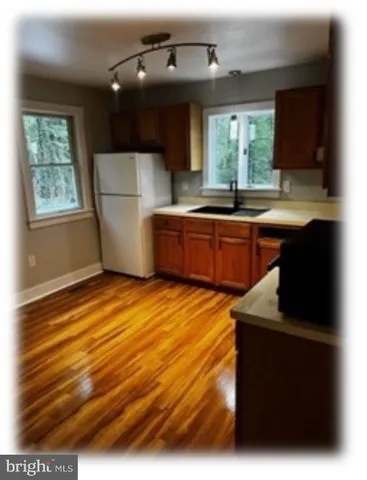 a kitchen with stainless steel appliances granite countertop a refrigerator a sink dishwasher a stove and a microwave oven