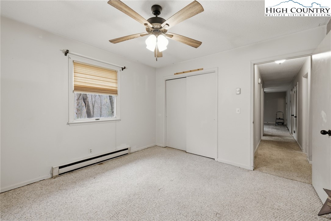 2202 Old 16 Highway Jefferson, NC 28640 - Photo 10 of 15 an empty room with windows and fan