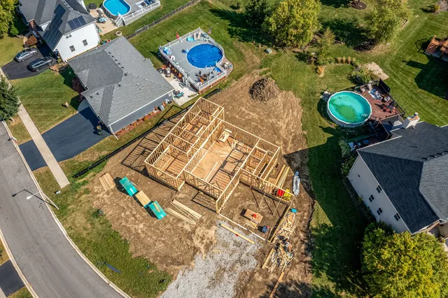 an aerial view of residential houses with outdoor space and parking