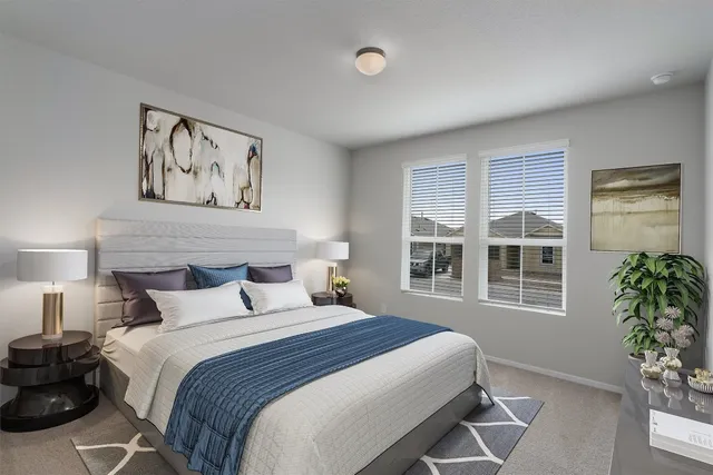 a bedroom with a large bed and potted plant