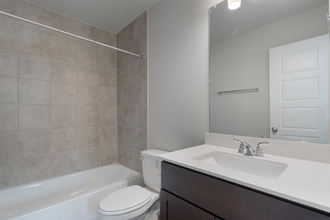 101 Keltic Drive Kyle, TX 78640 - Photo 26 of 29 a bathroom with a toilet a sink and a bathtub