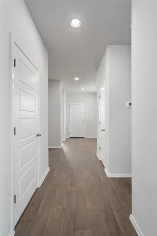 a view of a hallway with wooden floor