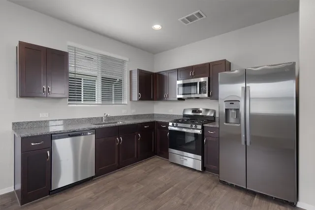 a kitchen with granite countertop stainless steel appliances and wooden cabinets