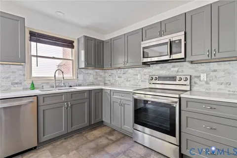 a kitchen with cabinets appliances and a sink
