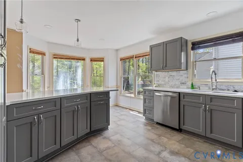 a large kitchen with kitchen island granite countertop a stove a sink dishwasher and wooden cabinets