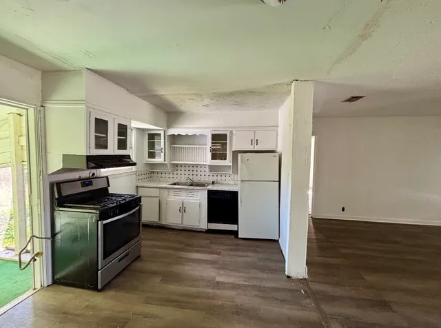 a kitchen with granite countertop a refrigerator stove and oven