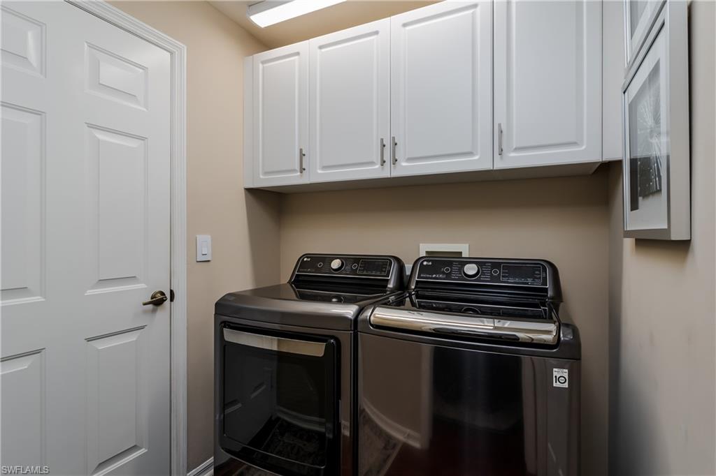6658 Castlelawn Place, Unit 9 Naples, FL 34113 - Photo 25 of 38 Laundry area featuring overhead white shaker-style cabinetry with brushed nickel hardware, a white paneled door, and neutral wall tones