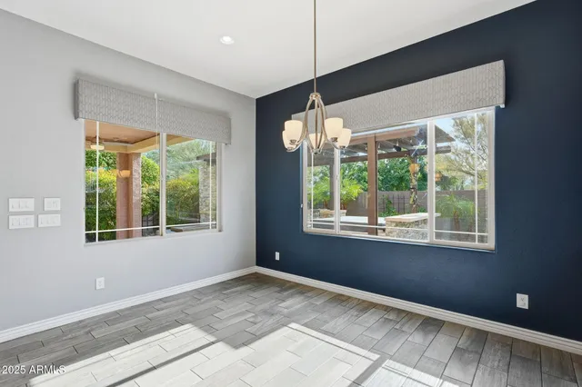a view of an empty room with a window and chandelier