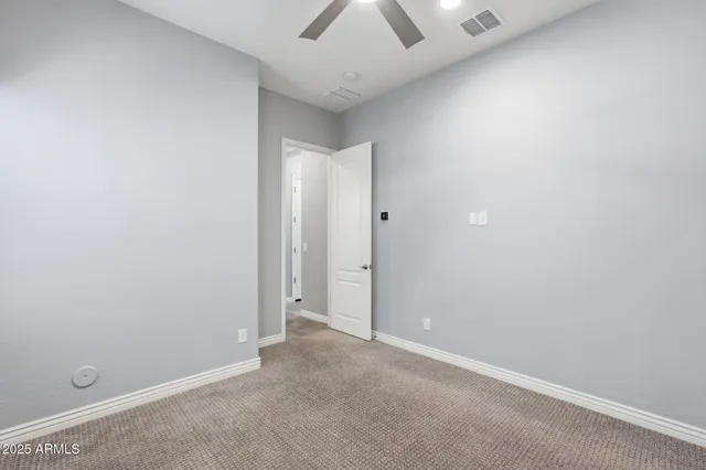 an empty room with a ceiling fan and a window