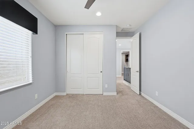 an empty room with windows and closet