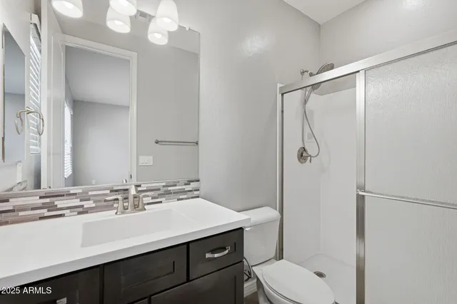 a bathroom with a sink toilet vanity and shower