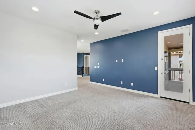 an empty room with closet and a ceiling fan