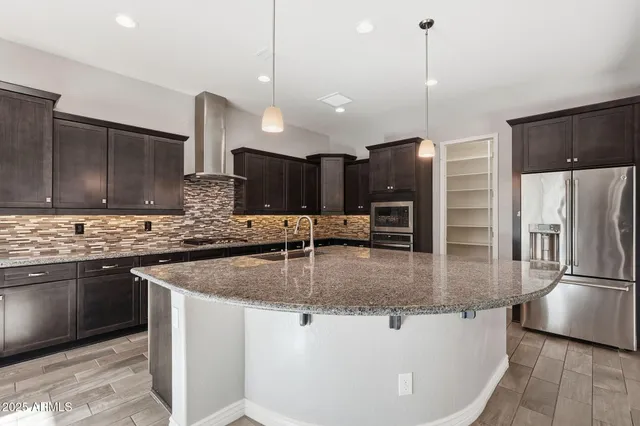 a kitchen with stainless steel appliances granite countertop a sink a stove and a refrigerator
