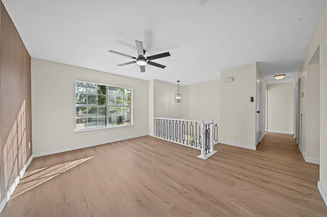 a kitchen with stainless steel appliances granite countertop a refrigerator a sink dishwasher a stove and a dining table with wooden floor