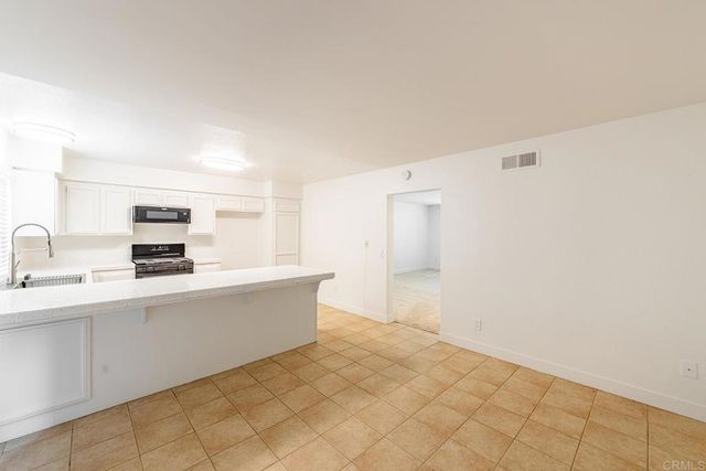 a room with a sink and a refrigerator