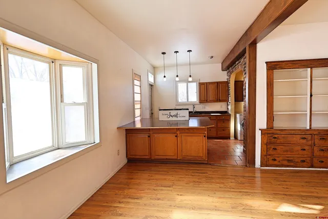 a large kitchen with stainless steel appliances kitchen island granite countertop a refrigerator and cabinets