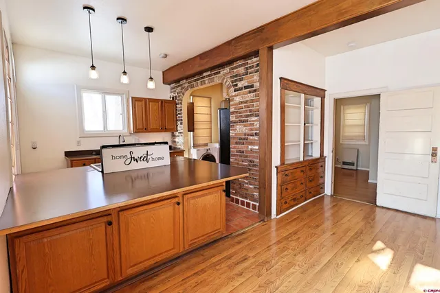 a view of a kitchen with wooden floor and electronic appliances