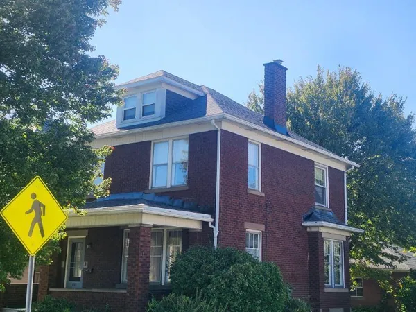 a front view of a house with a yard and trees