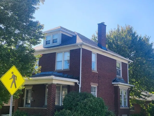 a front view of a house with a yard and trees
