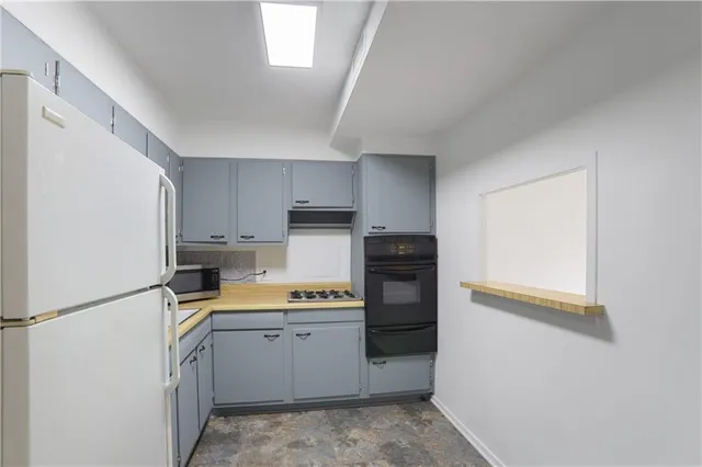 a kitchen with a refrigerator and a stove top oven