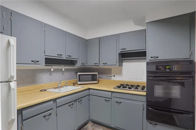 a kitchen with a sink stove and cabinets