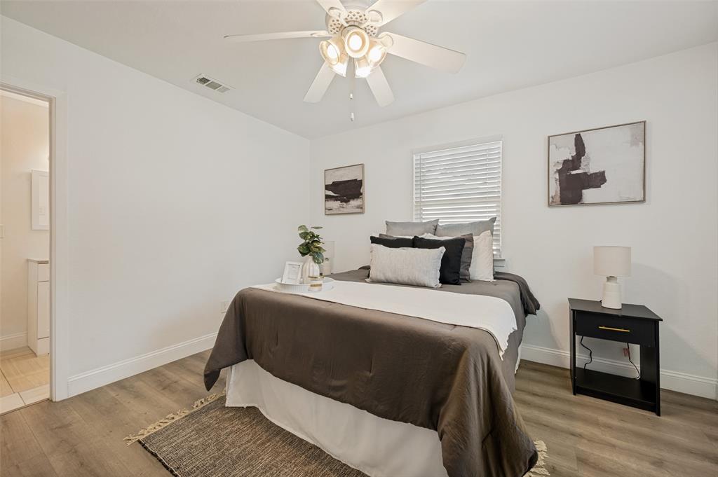 2316 Cunningham Street Irving, TX 75062 - Photo 11 of 22 Bedroom featuring light wood-finish flooring, white walls, and a ceiling fan with integrated lighting