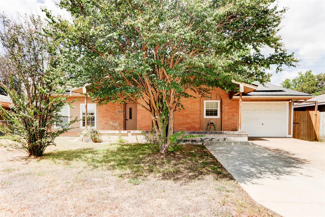 2402 Wilkes Street Bryan, TX 77803 - Photo 1 of 24 a front view of a house with a yard and garage