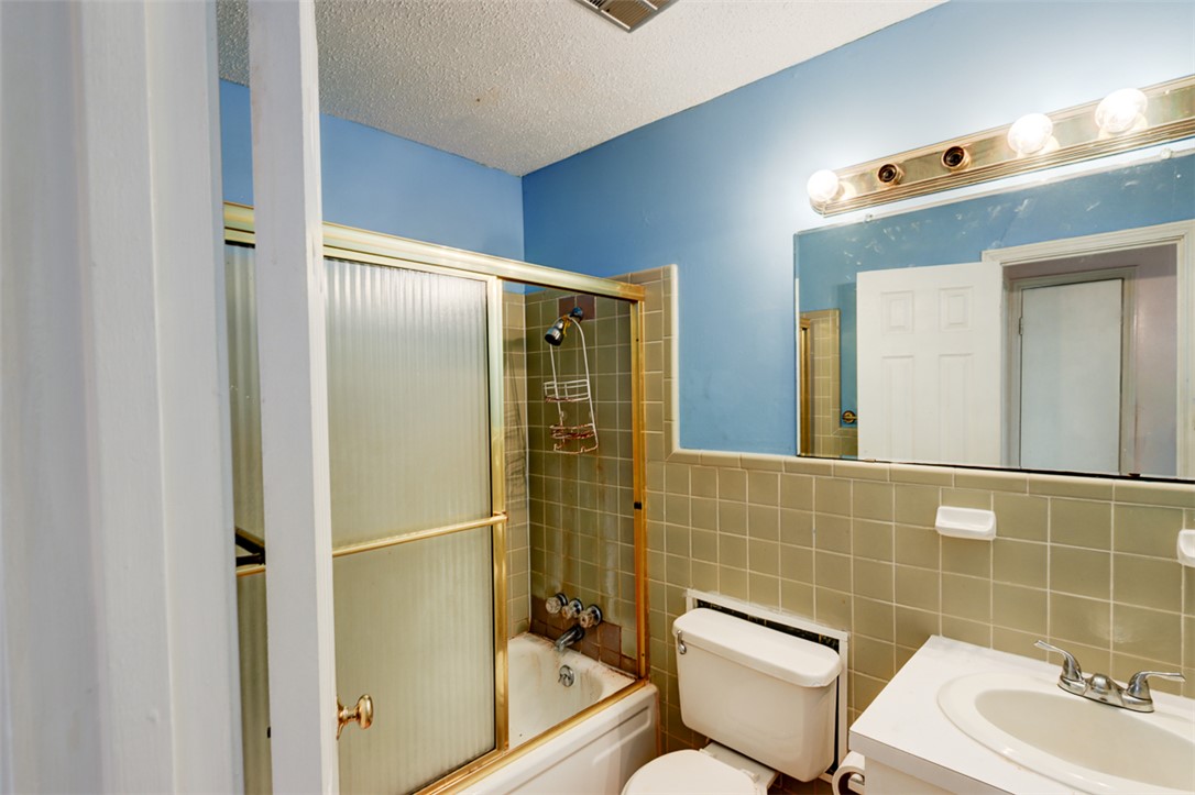 2402 Wilkes Street Bryan, TX 77803 - Photo 14 of 24 a bathroom with a toilet sink shower and mirror