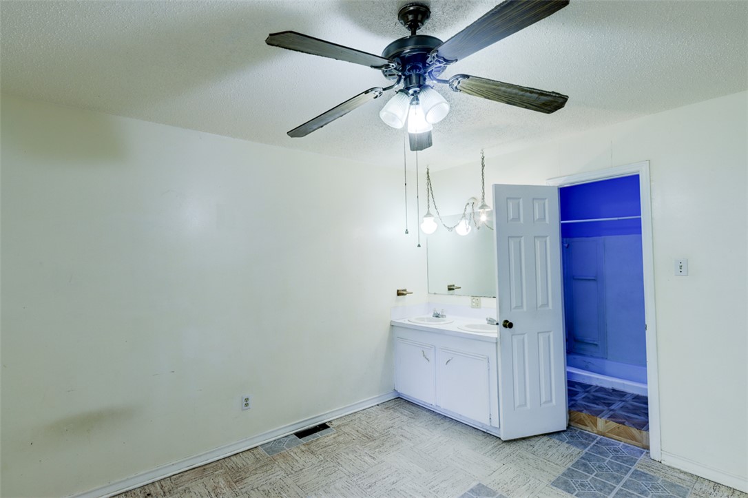 2402 Wilkes Street Bryan, TX 77803 - Photo 17 of 24 a view of a hallway with a chandelier fan and wooden floor