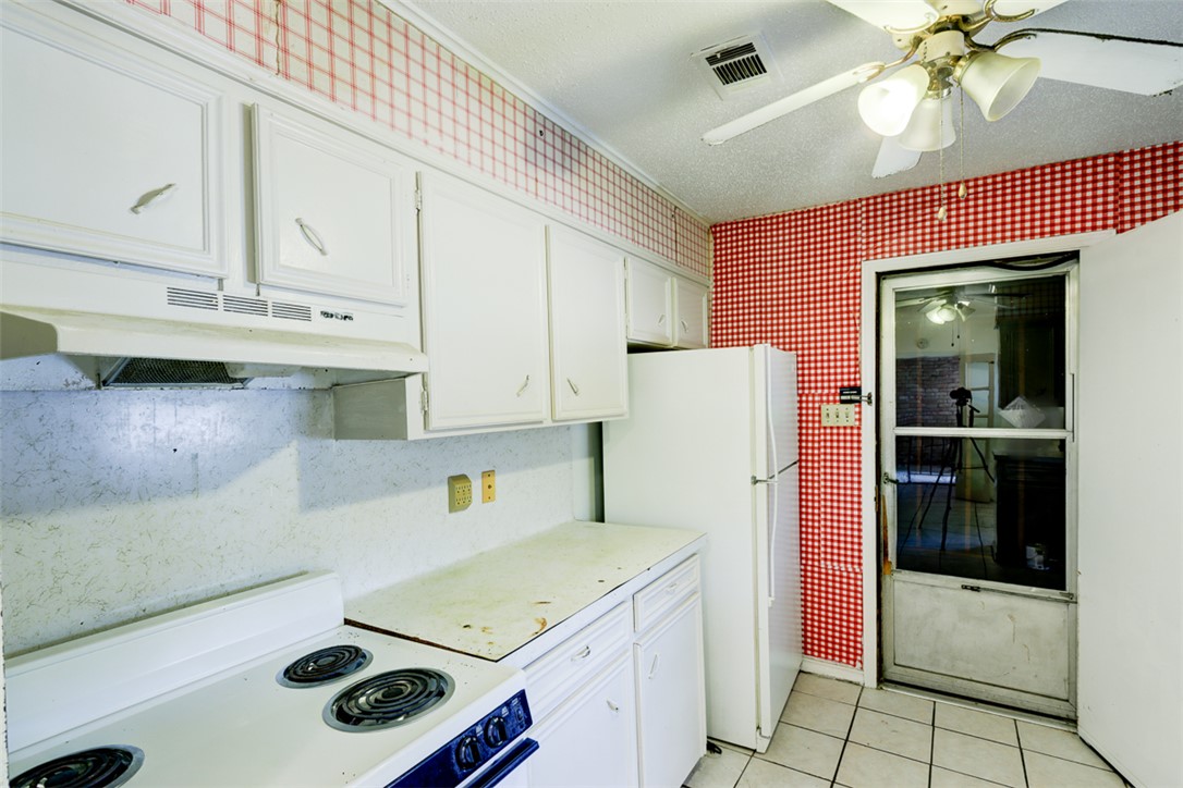2402 Wilkes Street Bryan, TX 77803 - Photo 7 of 24 a kitchen with a refrigerator a stove top oven and cabinets