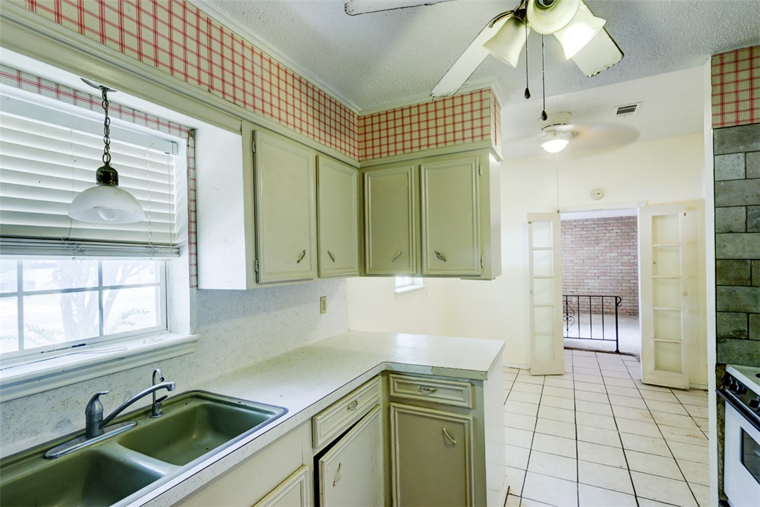 2402 Wilkes Street Bryan, TX 77803 - Photo 9 of 24 a kitchen with a sink cabinets and window