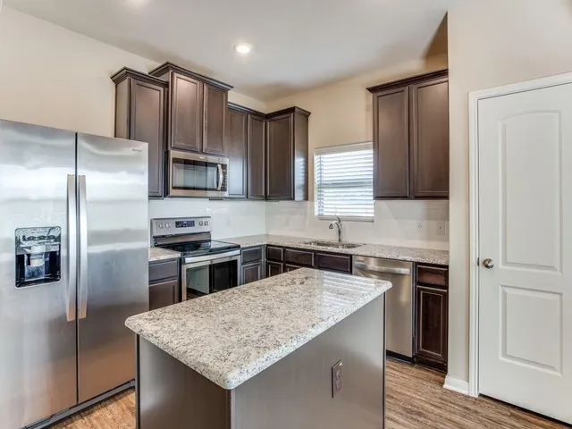 a kitchen with a refrigerator sink and microwave