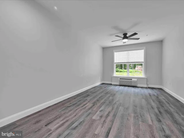 a large white kitchen with stainless steel appliances granite countertop a lot of counter space and wooden floors