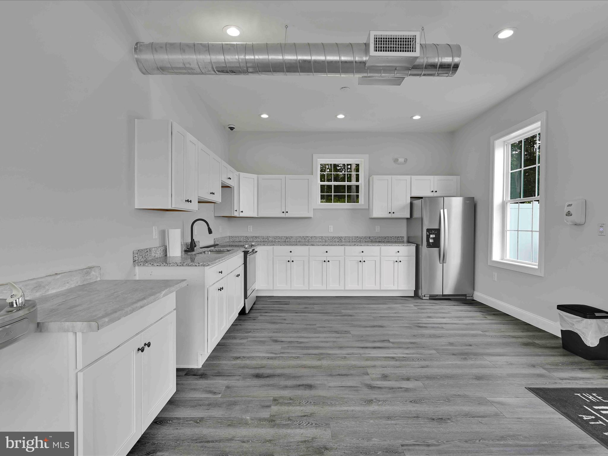 500-800 Paramount Boulevard, Unit 101312 Orwigsburg, PA 17961 - Photo 47 of 66 a large white kitchen with stainless steel appliances granite countertop a lot of counter space and wooden floors