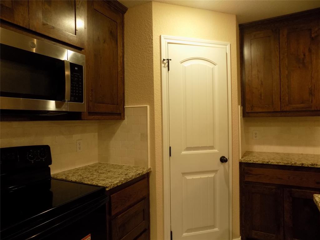 506 Pecan Tree Court Poolville, TX 76487 - Photo 12 of 36 View of pantry location along with some of the kitchen appliances
