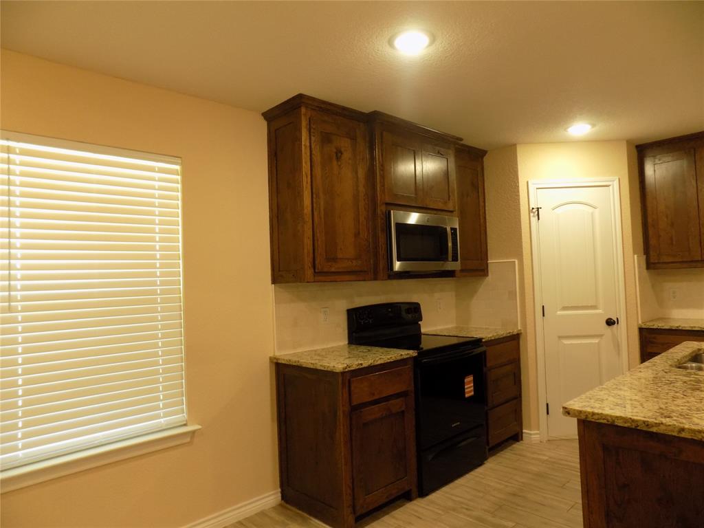 506 Pecan Tree Court Poolville, TX 76487 - Photo 15 of 36 Stove and microwave , along with pantry door
