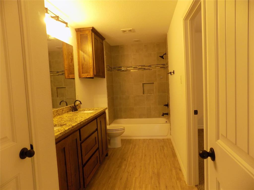 506 Pecan Tree Court Poolville, TX 76487 - Photo 22 of 36 Enter into large awesome bathroom; double sinks, granite counters, extra cabinet, beautiful tile work and door to walk-in closet