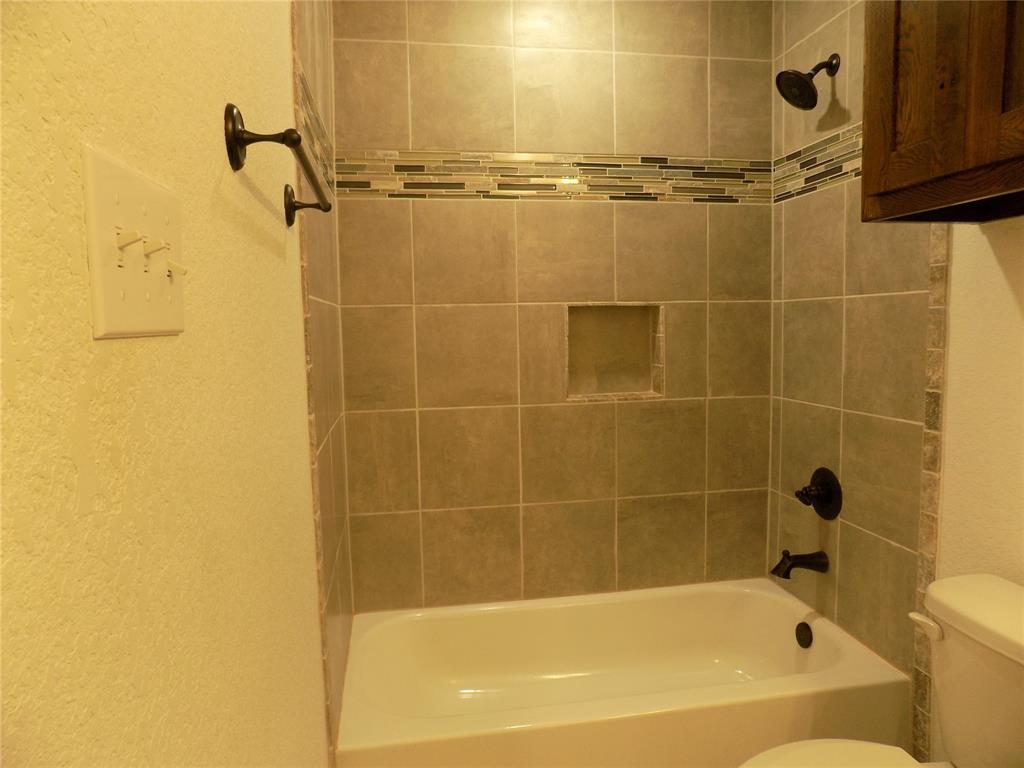 506 Pecan Tree Court Poolville, TX 76487 - Photo 7 of 36 Closer view of tiled bath tub and shower in guest bath