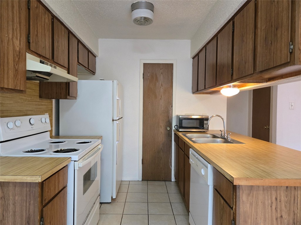 1404 Matthews Lane, Unit A Austin, TX 78745 - Photo 5 of 13 a kitchen with stainless steel appliances granite countertop a refrigerator a stove and a sink