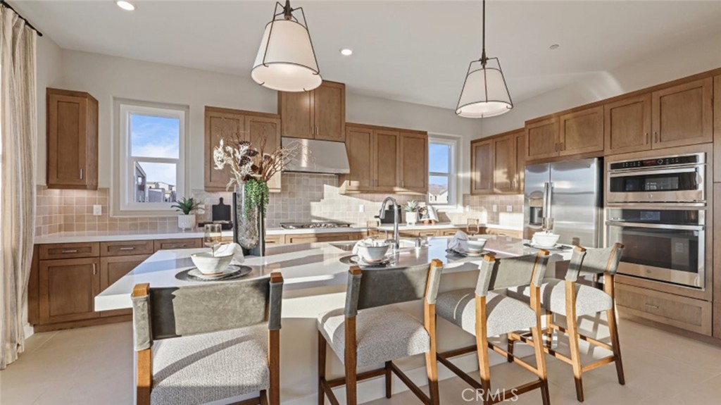 105 Proctor Irvine, CA 92618 - Photo 1 of 33 a kitchen with stainless steel appliances kitchen island granite countertop a dining table chairs sink and microwave