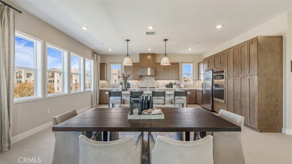 105 Proctor Irvine, CA 92618 - Photo 7 of 33 a kitchen with stainless steel appliances kitchen island granite countertop a dining table and chairs
