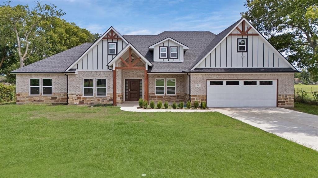 View of front of home featuring a shingled roof, a front yard, and board and batten siding