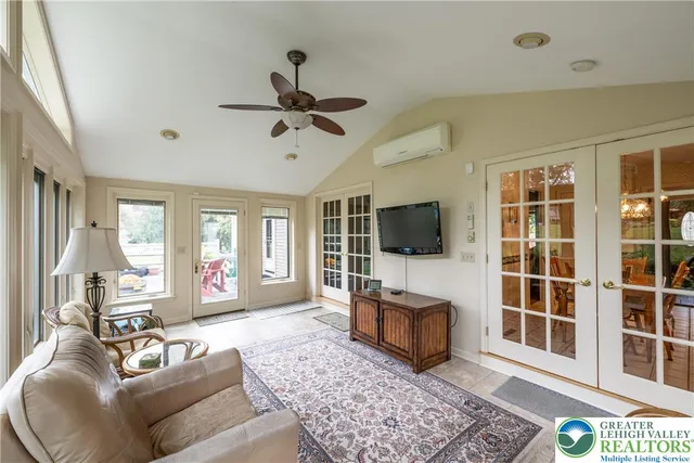 a living room with furniture a flat screen tv and a large window
