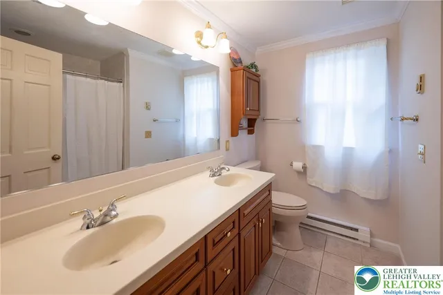 a bathroom with a sink a toilet and shower curtain