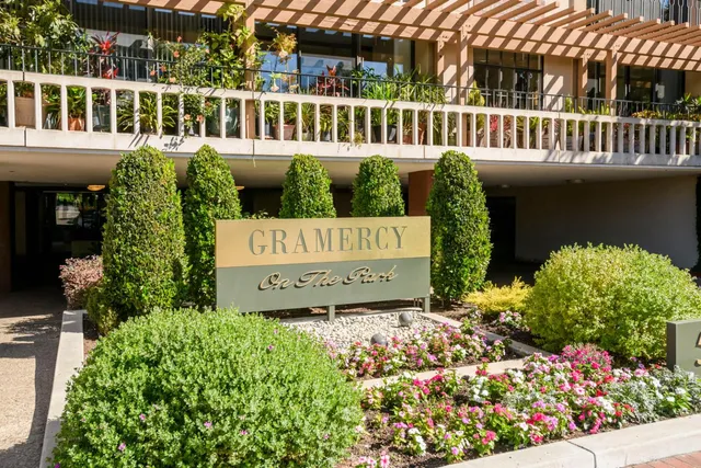 a view of a sign board with lots of flower plants
