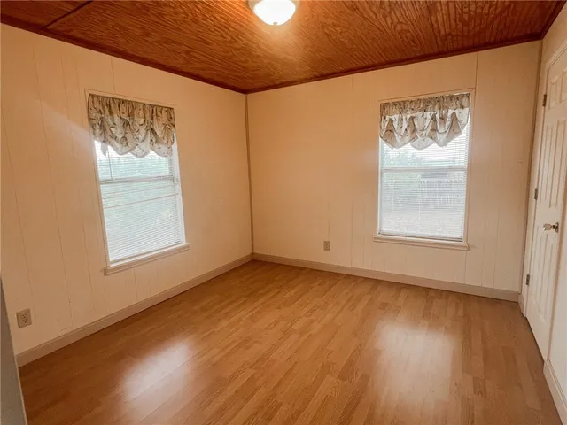 a view of a big room with wooden floor and windows