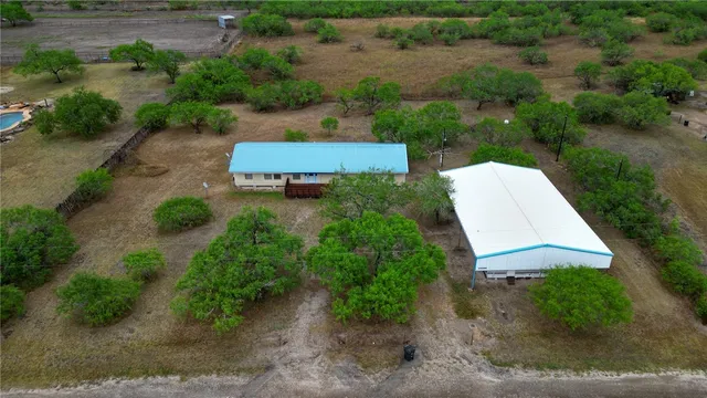 an aerial view of a house with a yard and lake view