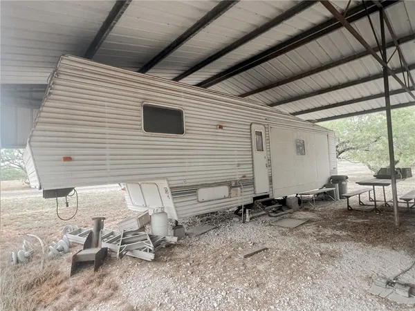 a view of a backyard with chairs and a large tree